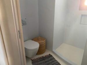 a small bathroom with a toilet and a basket at Rustic Stone House in the Heart of Folegandros in Áno Meriá