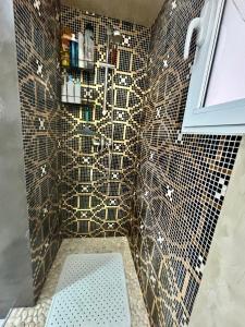 a bathroom with a tiled wall with a shower at Cute and Cosy habitación privada con balcón in Valencia