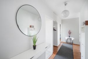 un couloir blanc avec un miroir rond sur le mur dans l'établissement Sari’s place with nice view, à Turku