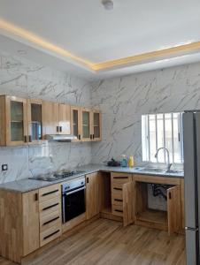 a kitchen with marble walls and wooden cabinets at Coin nickel in Cotonou