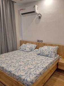 a bedroom with a bed with blue and white sheets at Coin nickel in Cotonou