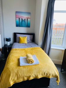a bedroom with a yellow bed with a towel on it at Cambois Elegance Beta in Cambois