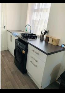 a kitchen with a stove and a washing machine at Cambois Elegance Beta in Cambois