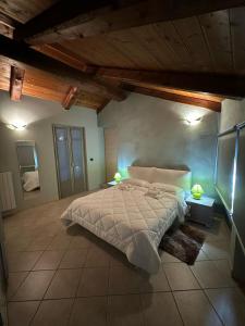 a bedroom with a large bed and two lamps on tables at La tana di Piozzo in Piozzo