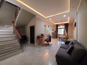 a living room with a couch and a table and stairs at Apartment in Vientiane