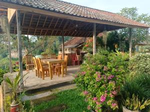 un patio con mesa y sillas bajo un pabellón en Suweden Homestay, en Jatiluwih