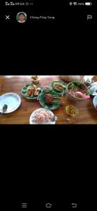 una mesa de madera con platos de comida. en Suweden Homestay, en Jatiluwih