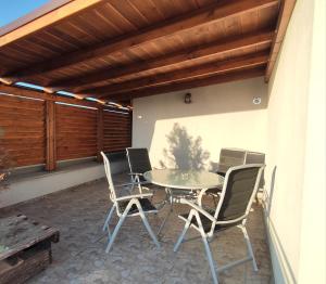 a patio with a table and chairs on a porch at Apartmán Dominika in Rovinka