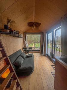 a living room with a couch and a table at Ekko tiny house in Philippeville