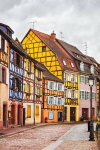a group of buildings on a cobblestone street at Schriner Hüss - Chambres d'hôtes & Gîtes in Beblenheim