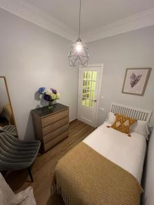 1 dormitorio con 1 cama, vestidor y silla en Amplio y céntrico piso con patio. en A Coruña