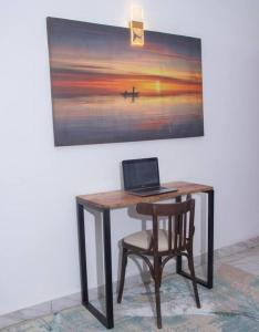 - un bureau avec un ordinateur portable et une chaise à côté d'un tableau dans l'établissement Mtwapa Musical Utopia apartment, à Mombasa