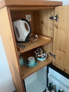 a wooden cabinet with a tv and dishes in it at Landhaus Aflenz in Aflenz Kurort