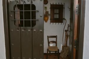 a gray cabinet with a chair in a room at Casa El Barbero 1810 in Benaocaz