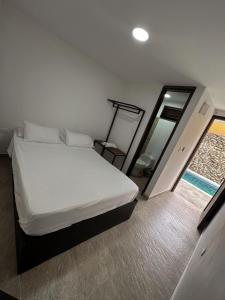 a small bedroom with a bed and a mirror at Hotel Victoria Queen Villavieja in Villavieja