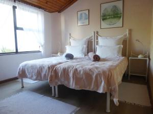 a bedroom with a bed with two hats on it at Birdsnest Guest Accommodation in Hout Bay