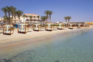 Protels Beach Club & SPA في مرسى علم: شاطئ فيه كراسي ومظلات بجانب الماء