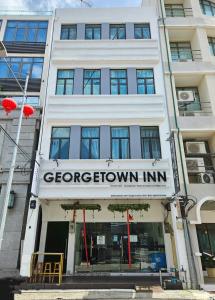 喬治市的住宿－Georgetown Inn by Sky Hive，一座白色的建筑,上面标有棕色旅馆