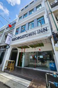 un edificio con un cartel en la parte delantera en Georgetown Inn by Sky Hive en George Town