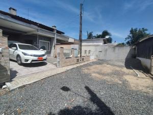 a white car parked in front of a house at Casa de Praia do Adriano in Itapoa