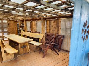 una mesa de madera y sillas en una terraza de madera en Nakvynė Biržuose “Širvėnos namai” en Biržai