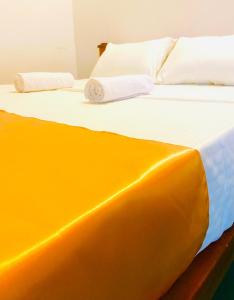 ein Bett mit zwei Kissen darüber in der Unterkunft Marina Way Hotel in Arugam Bay