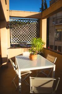 Espectacular Casa en La Garriga في لا جارايجا: طاولة وكراسي على شرفة مع نبات الفخار