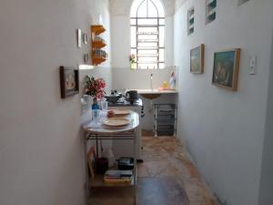 eine Küche mit einem Tisch und einem Waschbecken in einem Zimmer in der Unterkunft Casa Azul in Cascavel