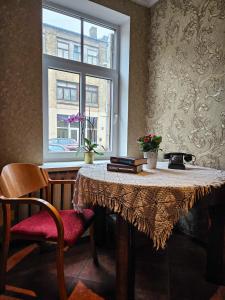 una mesa y una ventana en una habitación con mesa y sillas en Muzeja apartamenti, en Riga