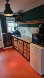 a kitchen with an orange floor and a counter top at Gastenhuisje in Zelhem