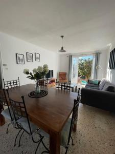 uma sala de estar com uma mesa de madeira e um sofá em Maison avec jardin à proximité de la plage et du canal du Midi pour 6 personnes em Portiragnes