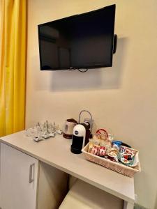 una mesa con un televisor en una pared con comida. en Casa Zeffirino, en San Remo