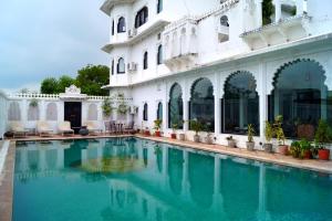 a swimming pool in front of a building at Karohi Haveli - A Heritage Hotel in Udaipur