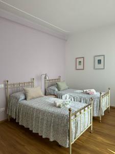 2 camas en una habitación con paredes blancas en Lucignolo, en Fucecchio