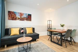 - un salon avec un canapé et une table dans l'établissement Deluxe Apartments Friedrichstrasse, à Fribourg-en-Brisgau