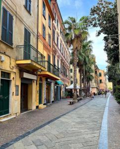 an empty street in a city with palm trees and buildings at Vico 2 monolocale in Albissola Marina
