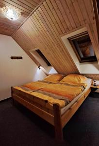 a bed in a room with a wooden ceiling at Ferienwohnung in Lemkenhafen auf Fehmarn in Fehmarn