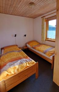 two beds in a room with a window at Ferienwohnung in Lemkenhafen auf Fehmarn in Fehmarn