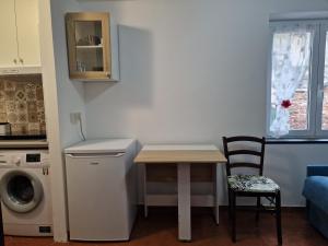 una piccola cucina con tavolo e lavatrice di Vico 2 monolocale ad Albissola Marina