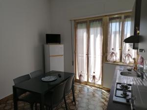 eine kleine Küche mit einem Tisch und einem Waschbecken sowie einem Tisch und Stühlen in der Unterkunft DonnaLory in Donnalucata
