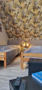 1 dormitorio con 2 camas y papel pintado en La CHAMBRE, en Évran