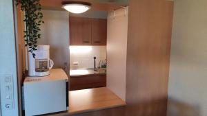 eine kleine Küche mit Kühlschrank und Spüle in der Unterkunft Hohegeiß Ferienwohunung - 14ter Etage mit Blick in Braunlage