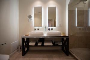 y baño con 2 lavabos y ducha. en Costamante Suites & Spa, en Castellammare del Golfo