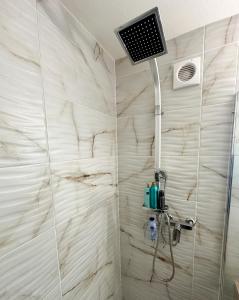 ein Bad mit einer Dusche und einem TV an der Wand in der Unterkunft Studio magnifique avec terrasse spacieuse Loèche-les-Bains Vacances in Leukerbad
