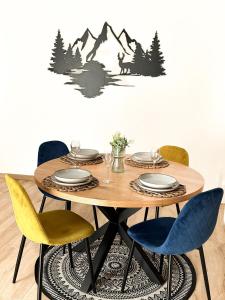 a dining room table with a table and chairs with mountains on a wall at Studio magnifique avec terrasse spacieuse Loèche-les-Bains Vacances in Leukerbad