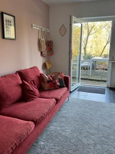 Stadtnahes Appartment mit Waldblick في فورتسبورغ: أريكة حمراء في غرفة المعيشة مع باب زجاجي منزلق