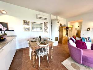 a living room with a table and a purple couch at Pequeno Paraiso-1RoomLet in São Brás de Alportel
