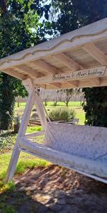 una mesa de picnic de madera con un cartel. en Lassu Tanya Vendégház, en Nagykőrös