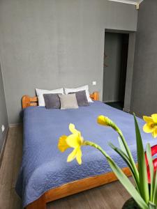 Un dormitorio con una cama con flores amarillas. en Muzeja apartamenti, en Riga