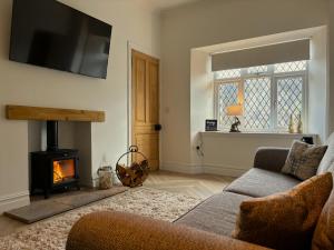 sala de estar con sofá y chimenea en The Gate Lodge, en Helensburgh